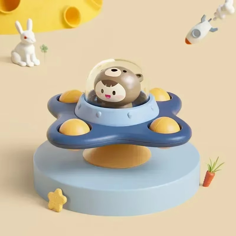 Infant reaching for a spinning suction cup toy on a smooth surface, enhancing motor development