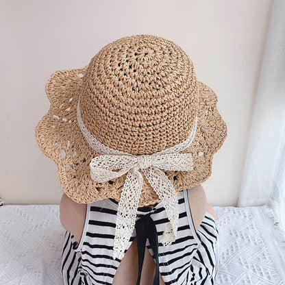 Baby straw sun protection hat with wide brim, perfect for toddlers playing outdoors in summer.