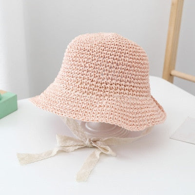 Close-up of a baby's woven straw sun hat, showcasing texture and wide brim for sun safety.