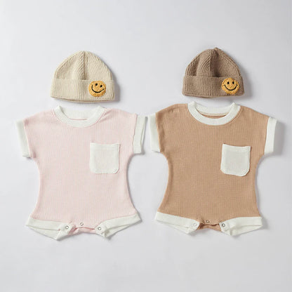 Collection of baby unisex waffle knit rompers in various pastel colors