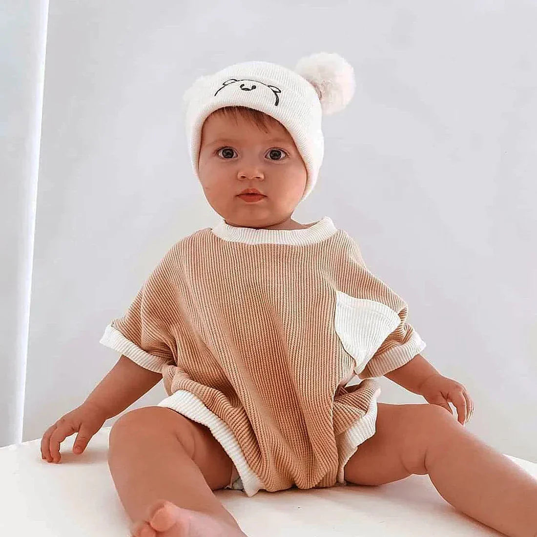 Close-up of waffle knit fabric on a baby romper, soft cotton texture