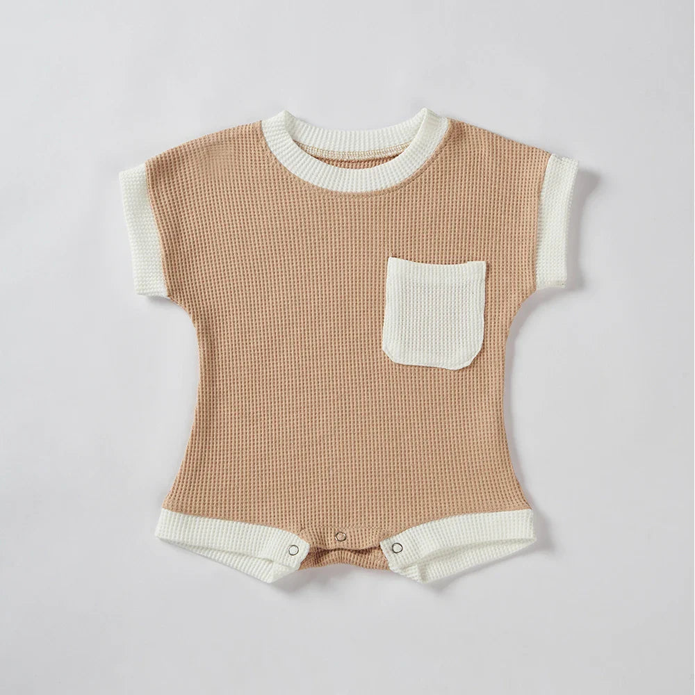 Detail of snaps on the bottom of a baby unisex cotton waffle knit romper