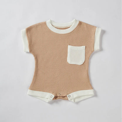 Detail of snaps on the bottom of a baby unisex cotton waffle knit romper