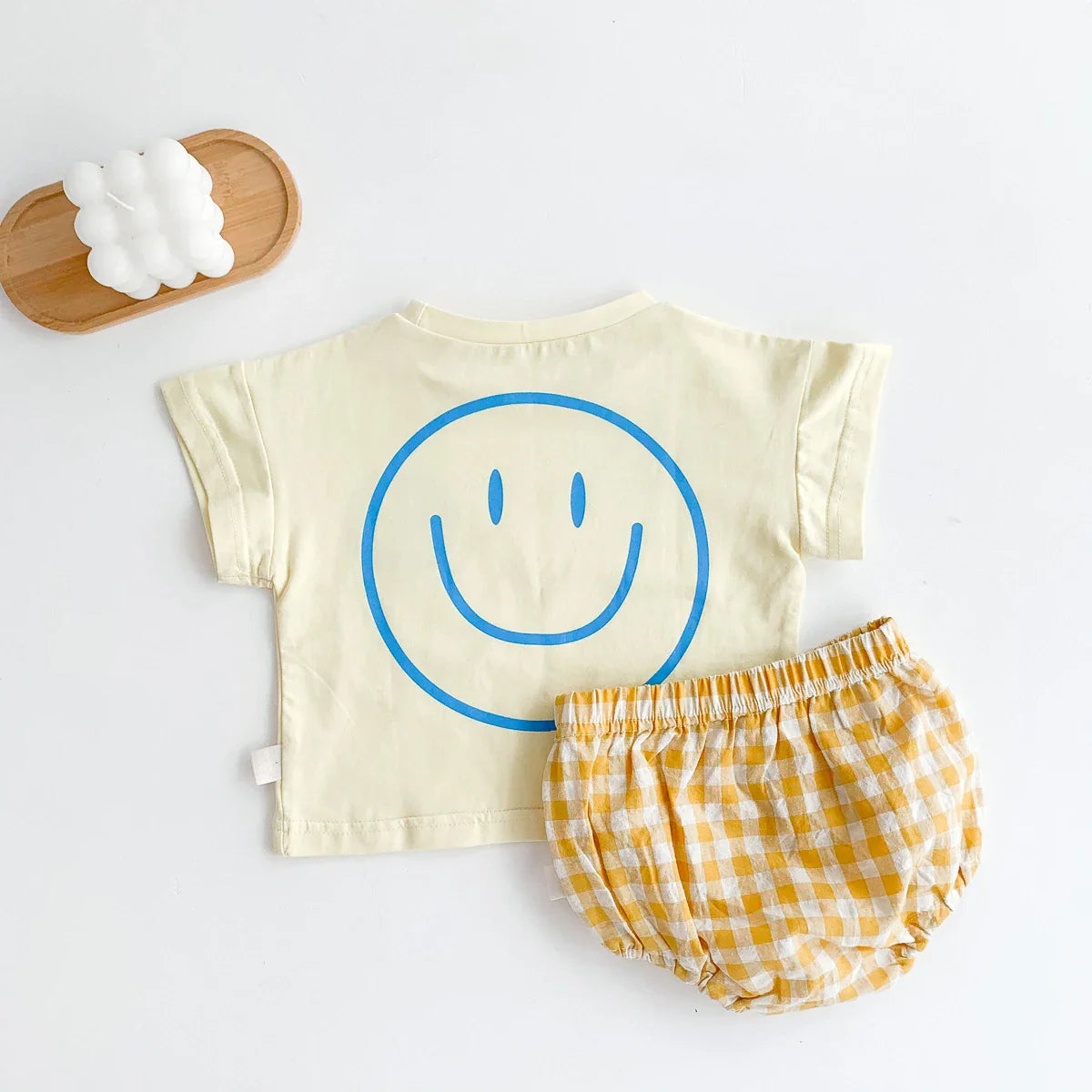 Smiling yellow face on a baby t-shirt with coordinating plaid shorts, unisex design