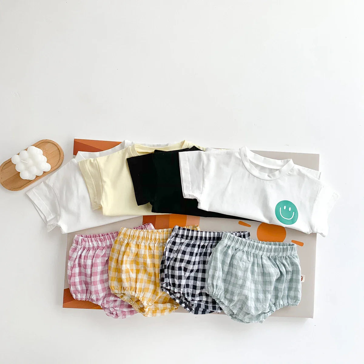 Baby apparel: white smile face t-shirt with green and blue plaid shorts, casual look