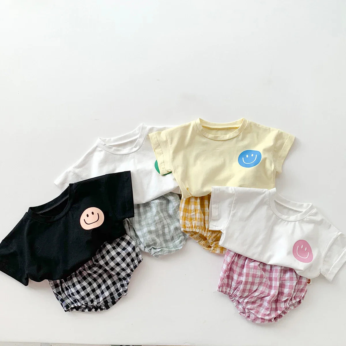 Unisex baby outfit with yellow smile face shirt and dark plaid shorts, infant apparel