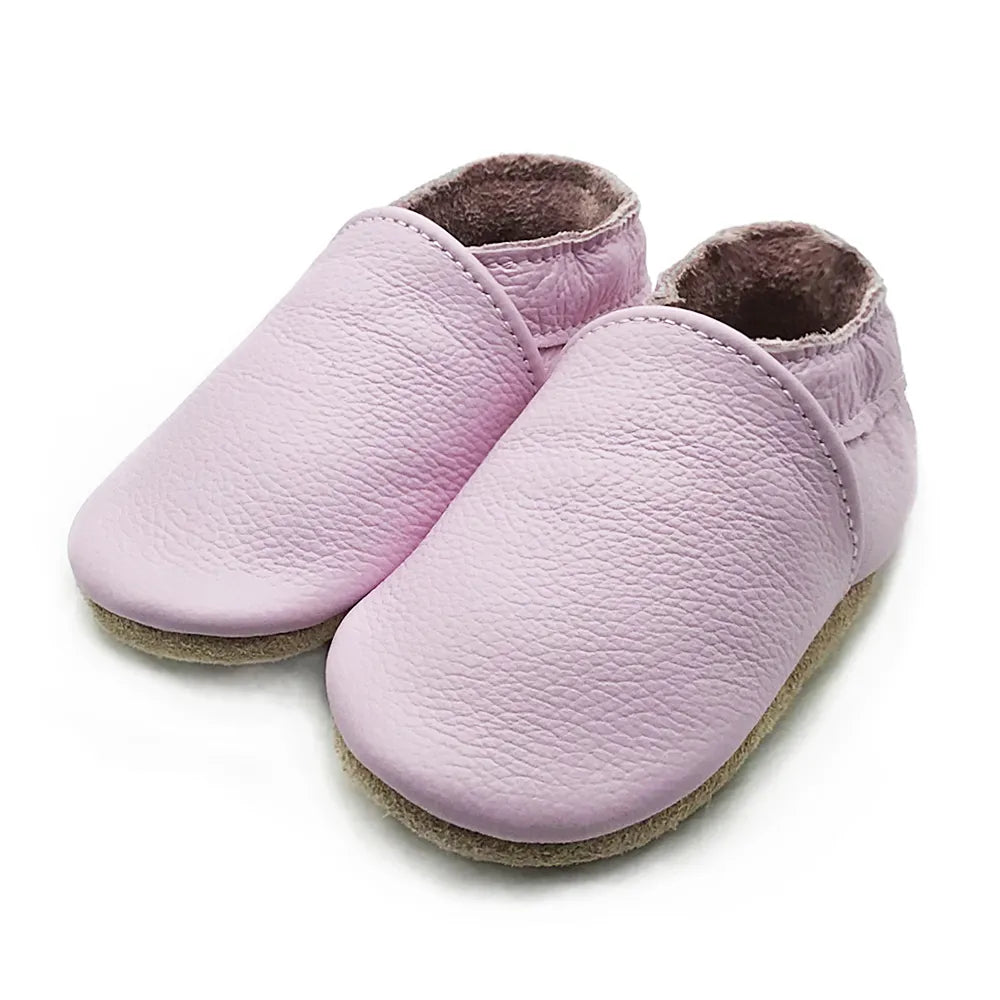 Baby's feet in black leather soft sole booties, unisex infant footwear with secure elastic