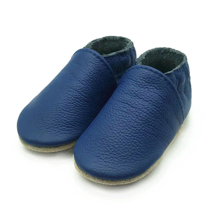 Pair of light blue leather baby booties on wooden surface, newborn & infant walking shoes