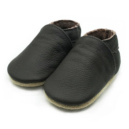 Unisex black soft leather baby booties on a clean background, infant first shoes