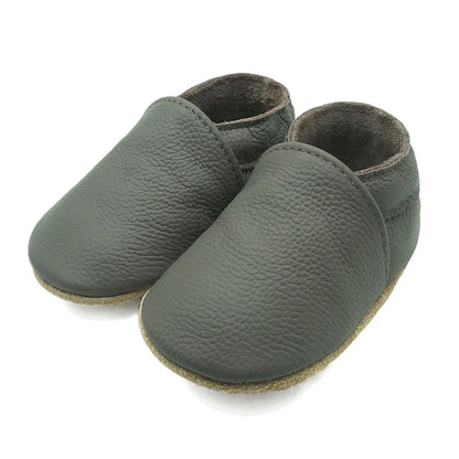 Close-up of an infant's foot in a soft leather baby bootie, cozy and flexible footwear