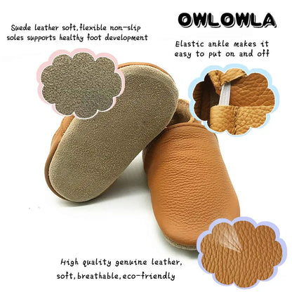 Pair of white soft sole leather booties for baby, unisex infant footwear with elastic