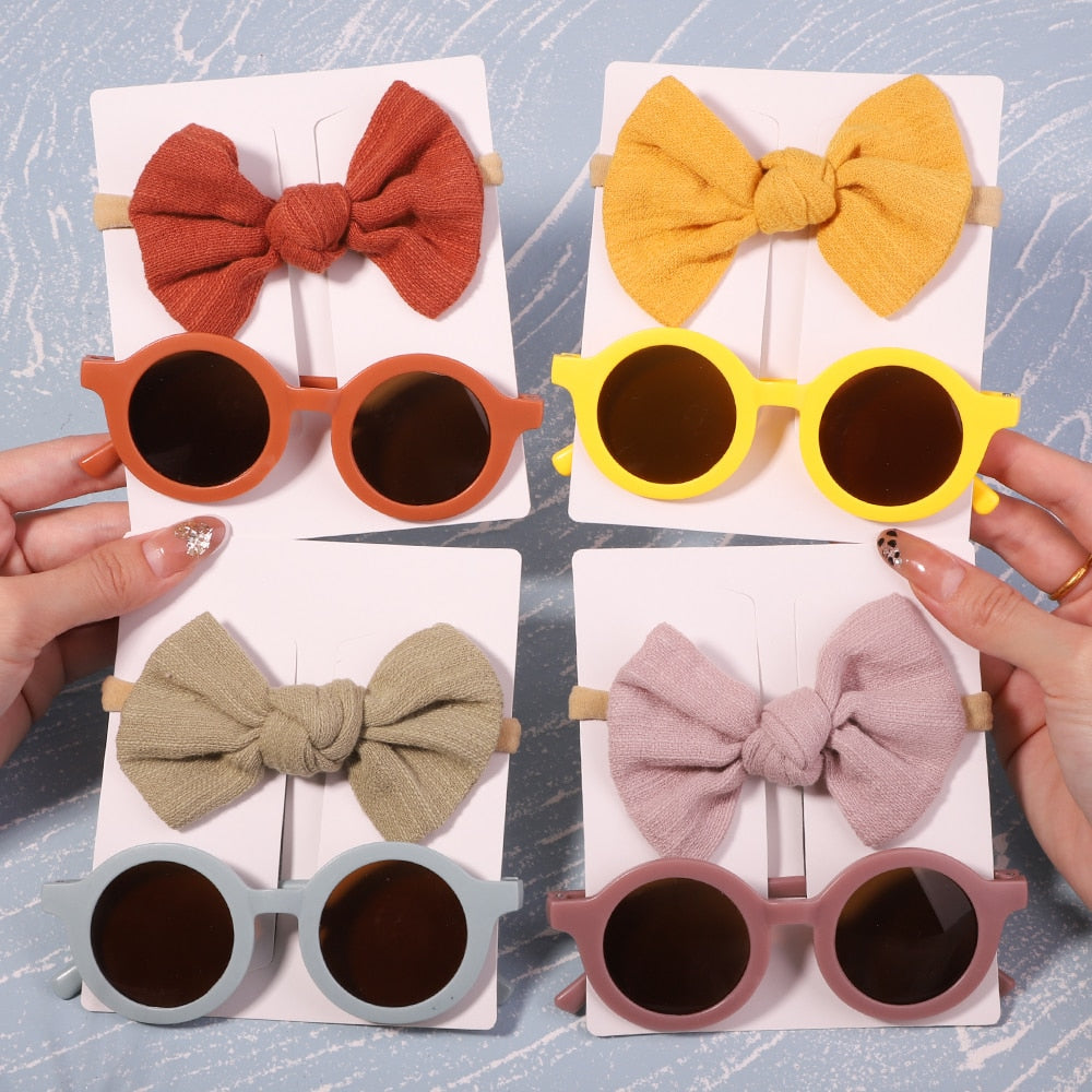Baby UV protective sunglasses & bow set. Infant eye protection, stylish accessory for sunny days.