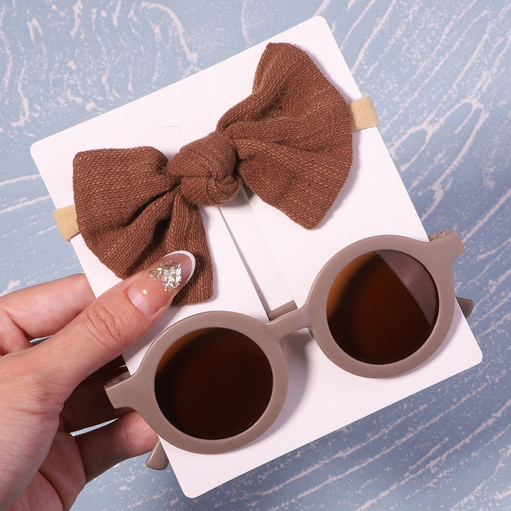Unisex baby UV sunglasses & bow set. Versatile eye protection & accessory for any infant.