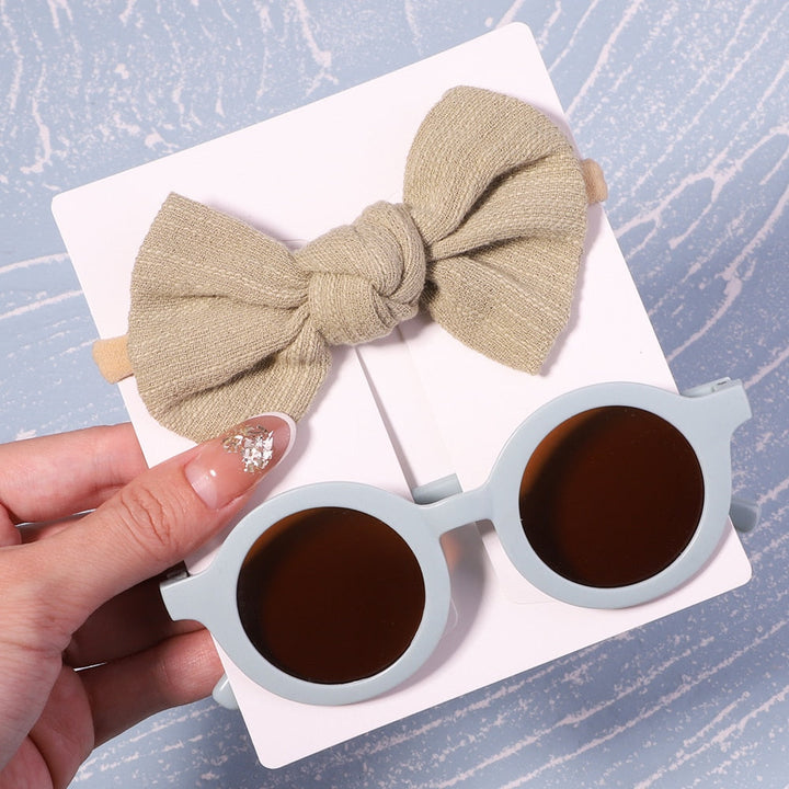 Essential baby sun gear: UV protective sunglasses & bow. Perfect for beach days & walks.