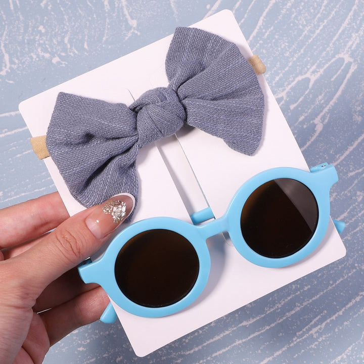 Secure fit baby UV sunglasses & gentle bow. Stays on while baby plays & explores safely.