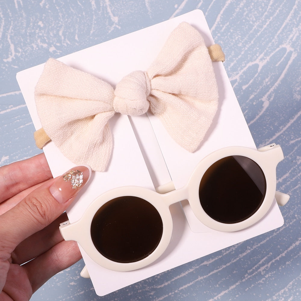 Baby gift idea: UV protective sunglasses & cute bow. Thoughtful and practical for new parents.