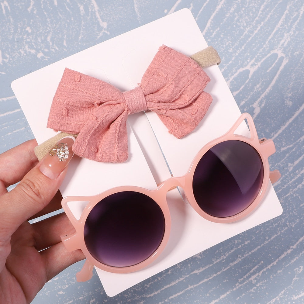 Adorable baby accessory set: UV protective sunglasses & hair bow. For cute & safe outdoor fun.
