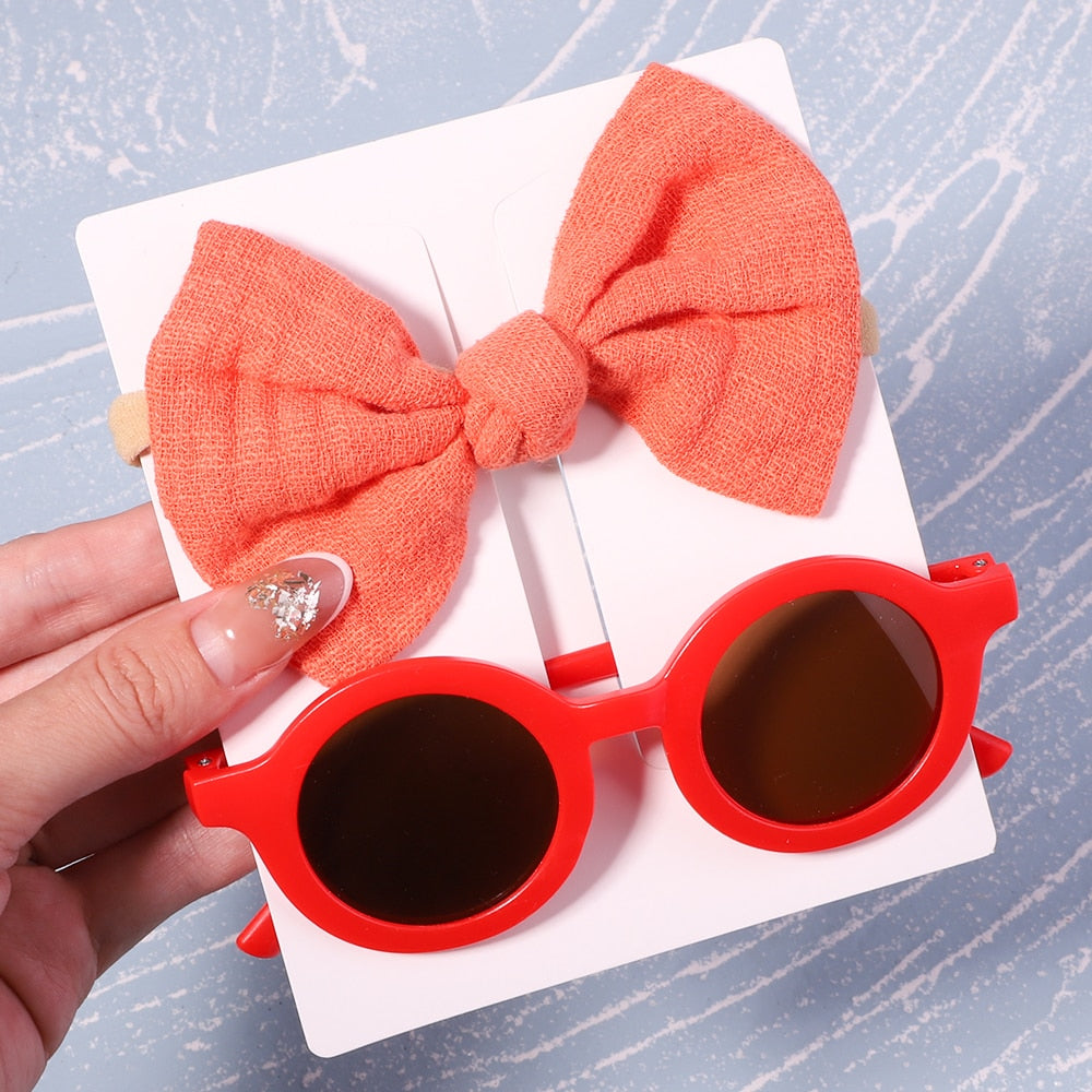 Infant sun protection set: UV sunglasses & cute bow. Keep baby's eyes safe and stylish outdoors.