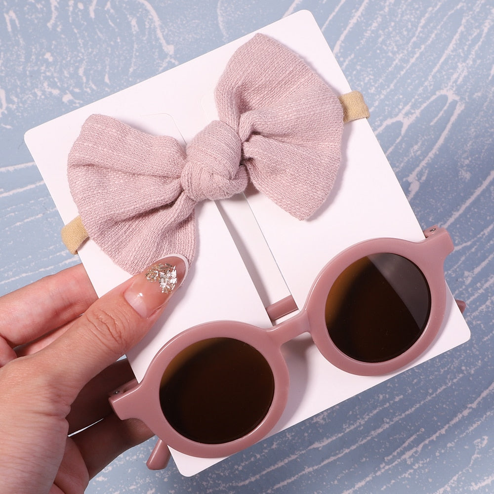 Baby fashion accessory: UV protective sunglasses & bow. Perfect for cute sunny day outfits.