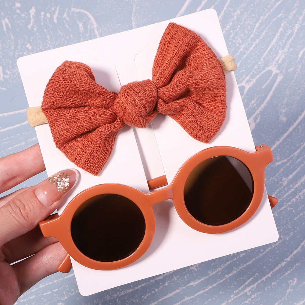 Gift-ready baby UV sunglasses & matching bow set. Essential sun protection for newborns & toddlers.