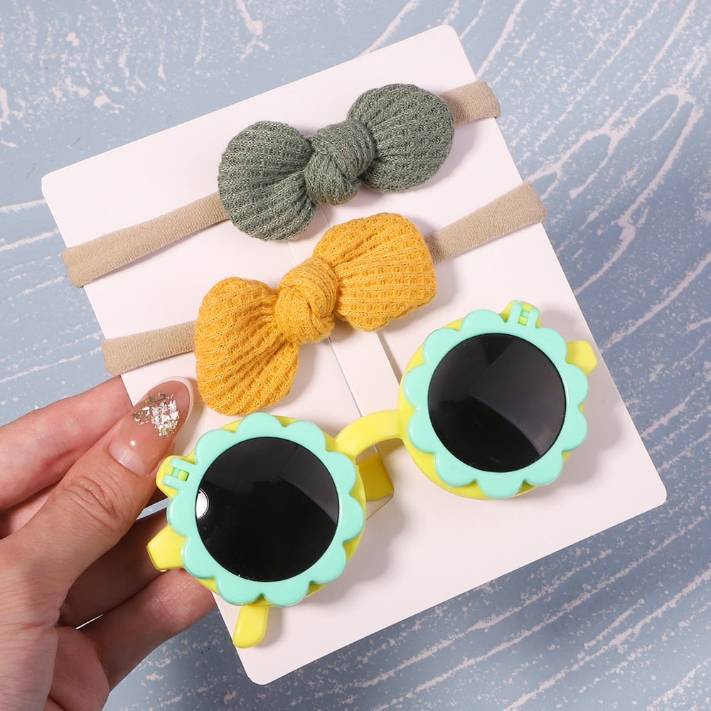 Protective baby sunglasses & hair bow set. Ensures infant eye safety & adds a touch of style.