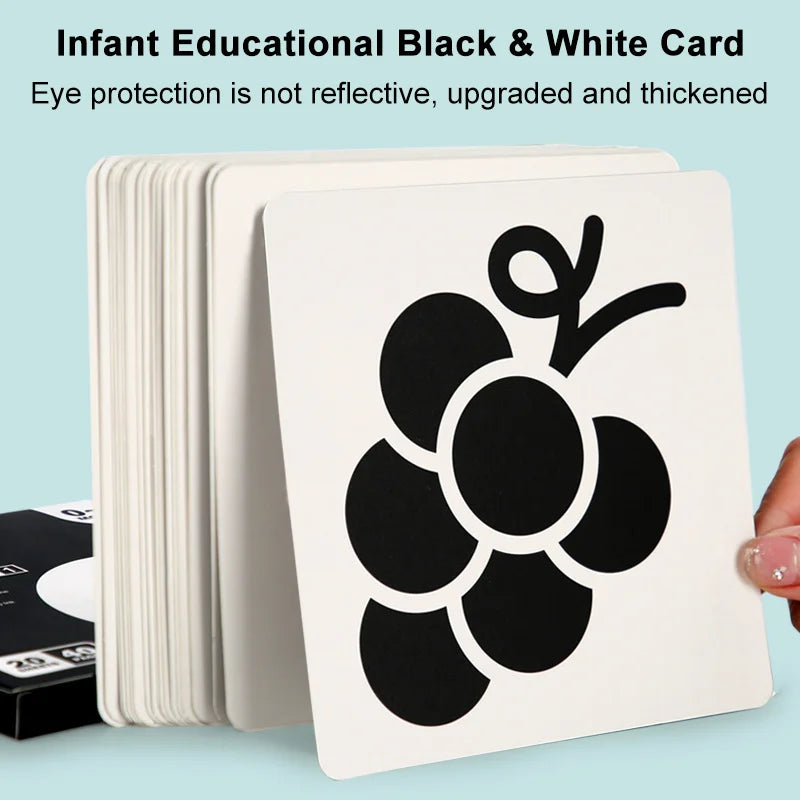 Close-up of a baby's hand reaching for a black and white vision development card, early learning