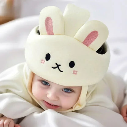 Baby wearing a soft, grey head protector helmet for crawling safety on a playmat