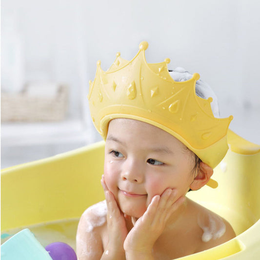 Baby wearing an adjustable no-tears shampoo visor bath cap, smiling during bath time fun.
