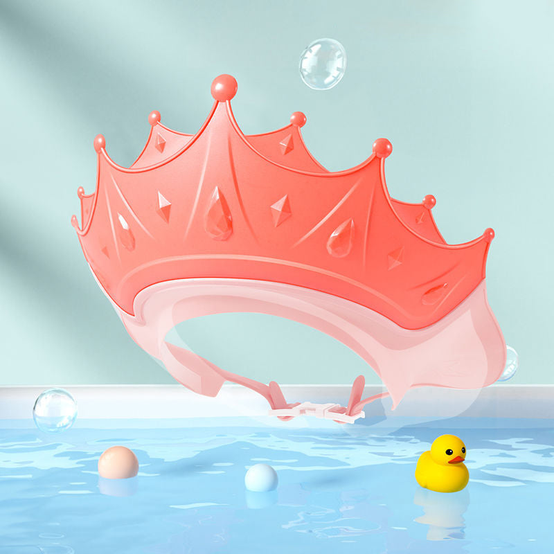 Toddler happily playing with bath toys while wearing an adjustable no-tears shampoo cap.