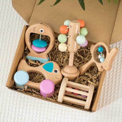 Natural wood baby sensory toys, including rattles and teethers, on a white background