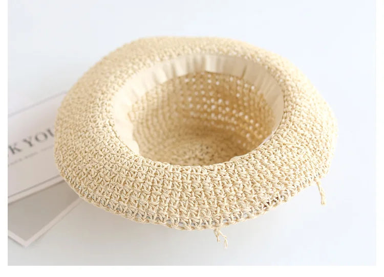 Foldable straw beach hat for children, beige, offering wide brim sun protection.