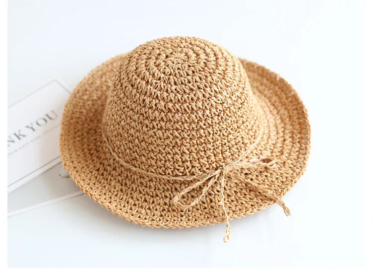 Children's foldable straw hat in brown, ideal for beach, park, and summer outings.