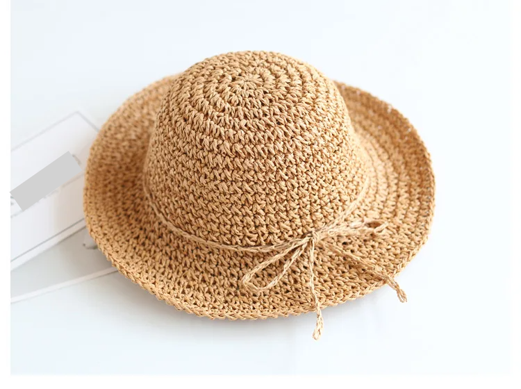 Kids' beige straw sun hat with a foldable design, essential for summer fun.