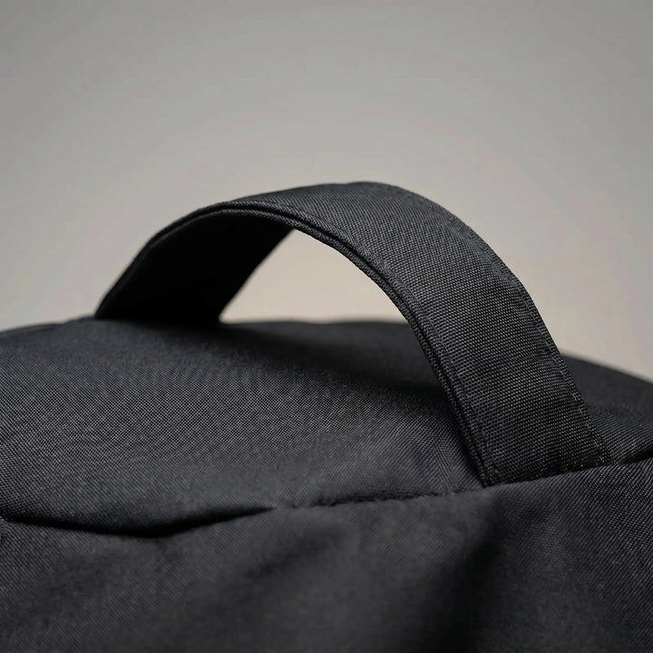 Heavy-duty black cylindrical BBQ grill cover for long-lasting outdoor weather protection in garden.
