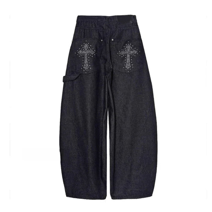 Detail of black studded wide-leg pants. Features unique stud embellishments, baggy silhouette, and low-rise design.