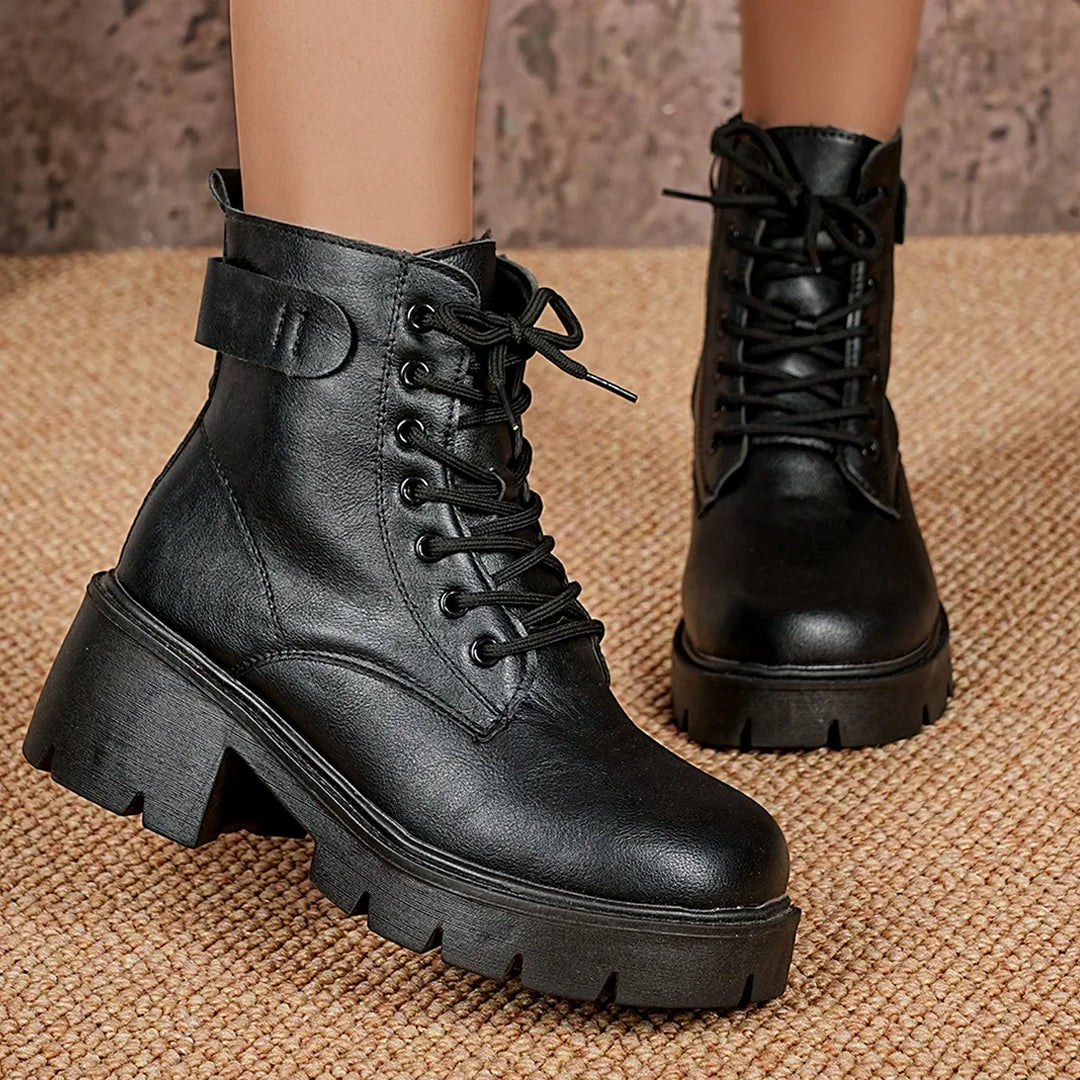 Edgy women's black lace-up ankle boots with a prominent chunky sole, ideal for modern winter outfits.