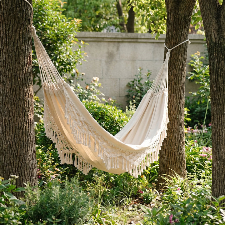 Bohemian tasseled cotton hanging hammock chair for single-person outdoor relaxation, perfect for patio or garden.