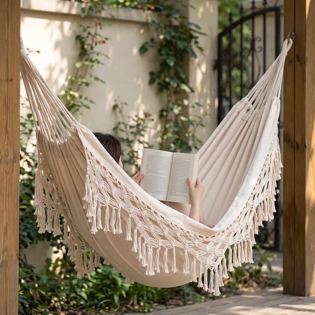 Comfortable bohemian tasseled cotton hanging bed for single-person outdoor relaxation, perfect porch swing.