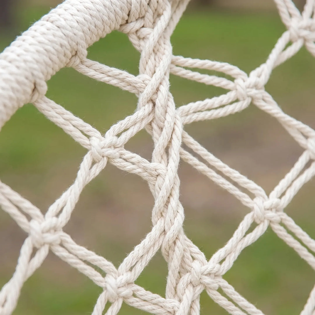 Intricate hand-woven macrame detail of a boho hanging hammock chair. Textile art for comfortable swing seating.