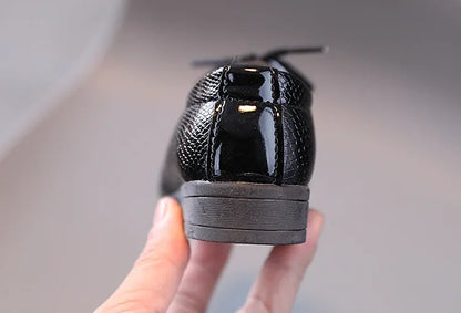 Boys' black dress shoes, essential for any formal event, including school photos.