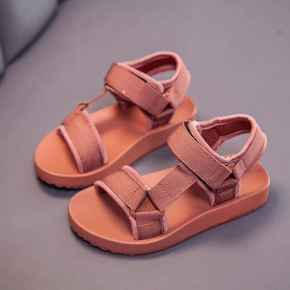 Side view of boys' canvas sandal, highlighting the secure hook and loop closure and flat sole