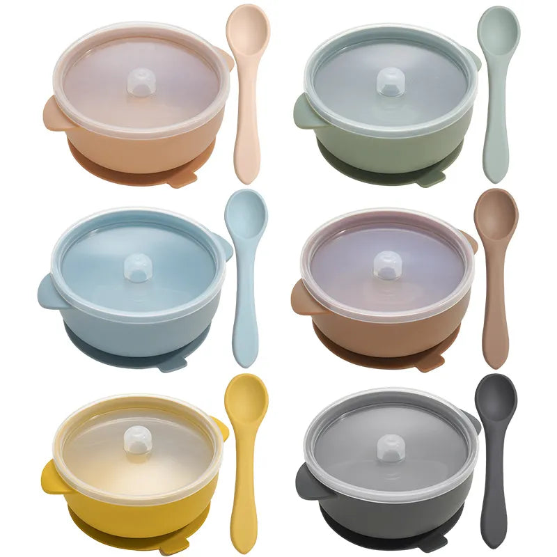 BPA-free silicone baby feeding bowl set with suction, lid, and spoon in light blue for toddlers on wooden table
