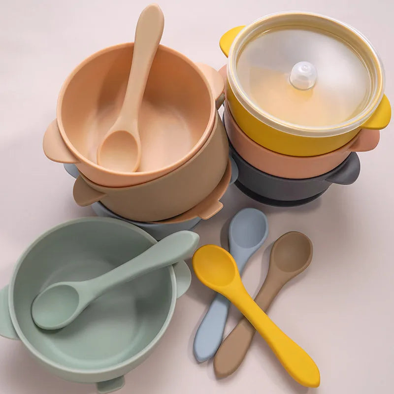 Close-up of peach BPA-free silicone baby bowl with matching spoon on a white background, ideal for weaning