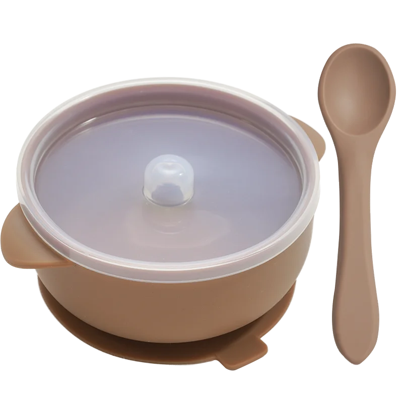 Hand holding a soft BPA-free silicone baby spoon from the feeding set, gentle on baby's gums