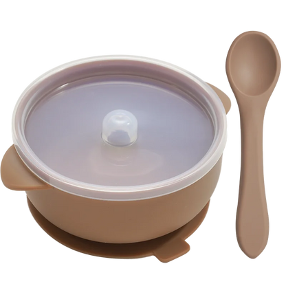 Hand holding a soft BPA-free silicone baby spoon from the feeding set, gentle on baby's gums