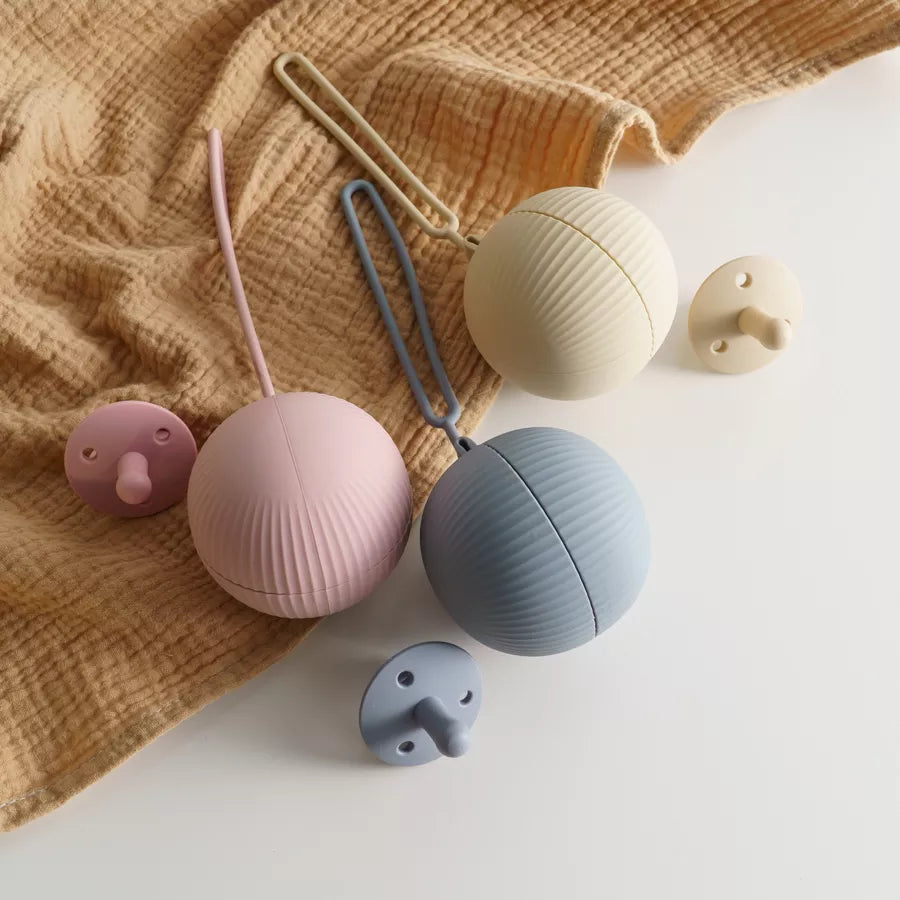 BPA-free silicone pacifier holder in pastel pink, securely storing a baby soother, hygienic travel case for newborns