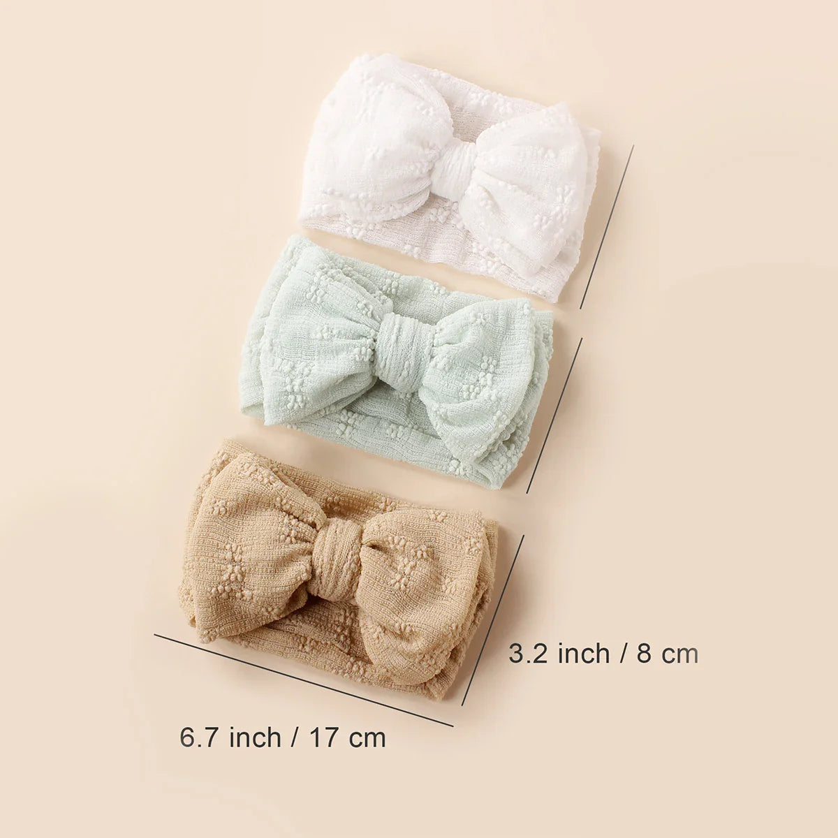 Stack of colorful baby breathable mesh double bow turban headbands, ideal infant accessory.
