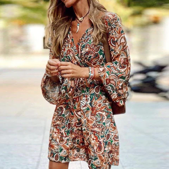 Flowy bohemian mini dress for women featuring a chic paisley print, V-neck, and smocked lantern sleeves. Casual summer style.