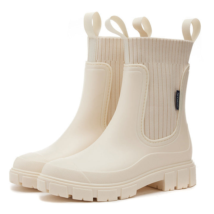 Woman wearing stylish waterproof all-weather boots, walking outdoors. Perfect chic footwear for rainy days.