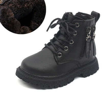 Child's foot wearing black waterproof ankle boot, zip closed, ready for winter play